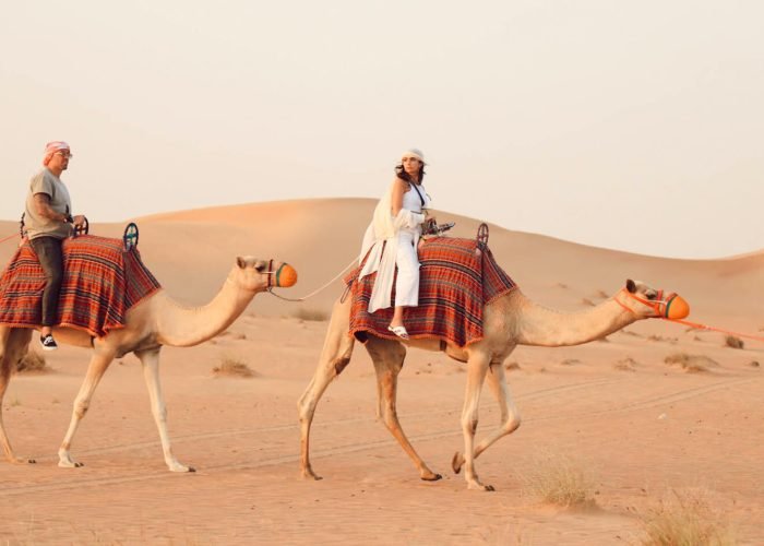 Una Grande Foto Di Alcuni Turisti Che Passeggiano Su Dei Camelli Durante Un Safari A Hurghada