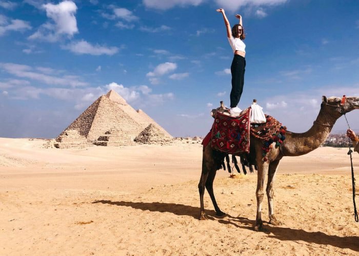Una Grande Foto Di Una Turista Donna In Piedi Su Un Cammello