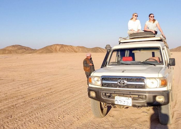 Una Meravigliosa Foto Di Due Ragazze Sedute Su Un Veicolo A Quattro Ruote Motoriche Durante Un Viaggio Safari